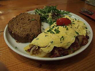Egg omelet or scrambled egg, with tomatoes, fat added
